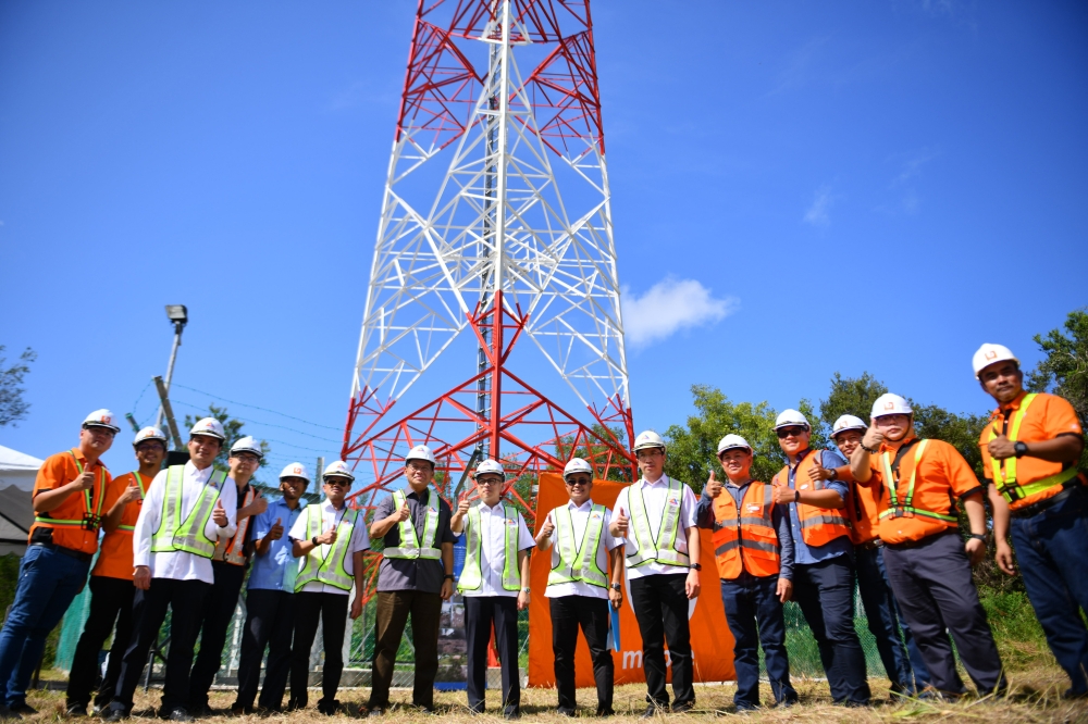 Communications Minister Fahmi Fadzil poses in front of the telecommunications tower during the Visit to the Jendela telecommunications Tower in Kampung Sungai Aur in Kuching November 10, 2024. — Bernama pic