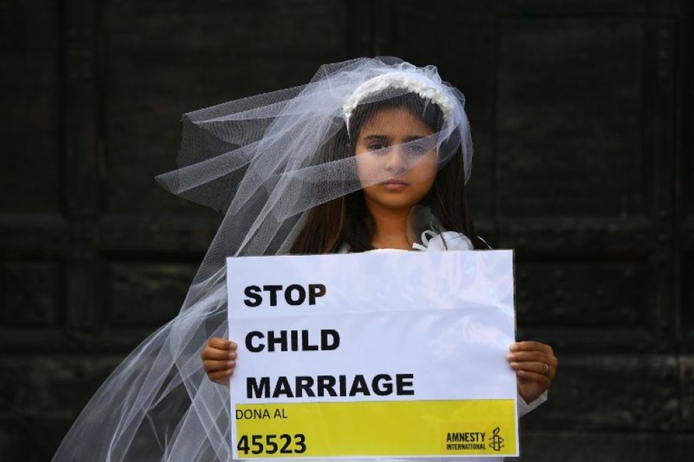 A young actress plays the role of Giorgia, 10, forced to marry Paolo, 47, during a happening organised by Amnesty International to denounce child marriage, in this file picture taken on October 27, 2016 in Rome. — AFP pic