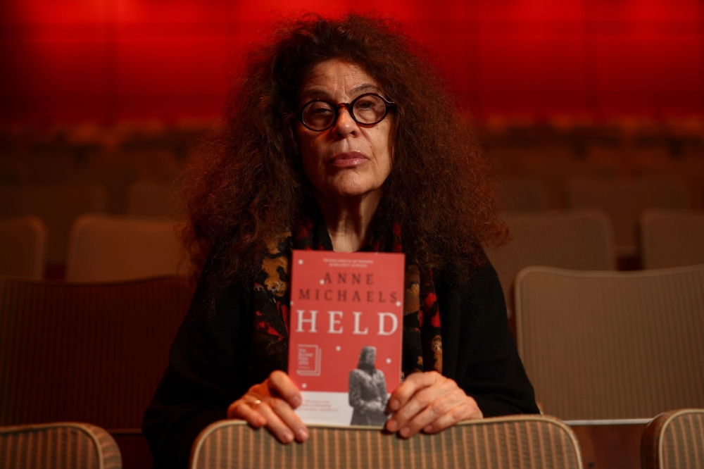 Canadian writer and Booker Prize 2024 shortlisted author Anne Michaels poses with her book 'Held' during the Booker Prize 2024 Award photo call event. — AFP pic