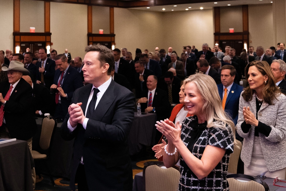 Tesla and SpaceX CEO Elon Musk (L) listens as US President-elect Donald Trump speaks during a meeting with House Republicans at the Hyatt Regency hotel in Washington. — AFP pic