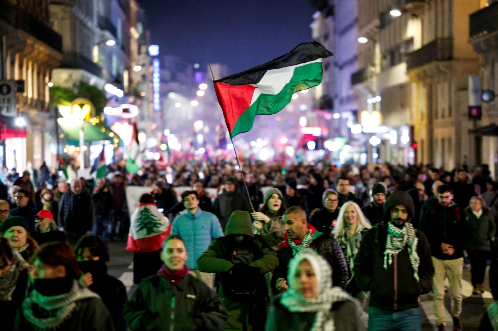 A woman waves a Palestinian flag, as people attend a demonstration in support of Palestinians, ahead of UEFA Nations League France-Israel soccer match, amid the ongoing conflict between Israel and Hamas in Gaza and the hostilities between Hezbollah and Israeli forces, in Paris, France, November 13, 2024. — Reuters pic