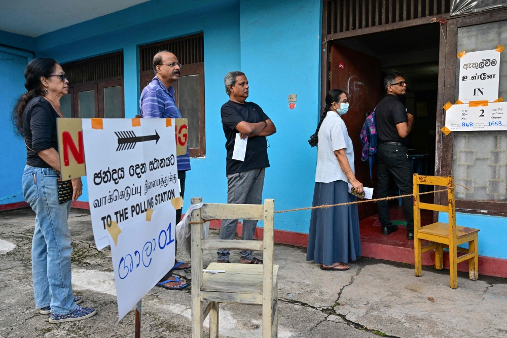 People queue at a polling station before casting their ballots to vote in Sri Lanka's parliamentary election in Colombo on November 14, 2024.  — AFP pic