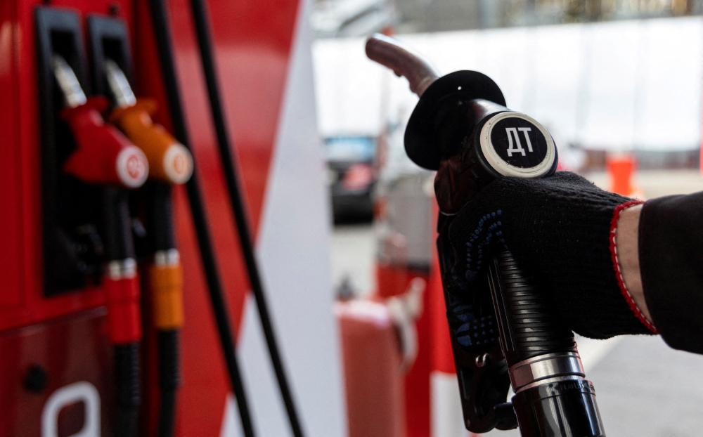 An employee holds a diesel fuel pump nozzle at a petrol station of Neftmagistral company in Moscow September 8, 2023. Governments around the globe are subsidising fossil fuels to protect consumers by keeping prices low. The biggest spenders, according to the IEA, are Russia, Iran, China and Saudi Arabia — countries that can, broadly, afford the costs. — Reuters pic