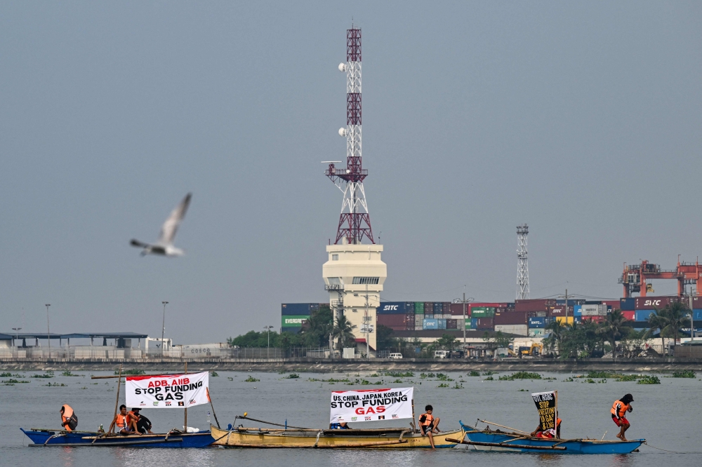 An environmental group onboard wooden boats stage a demonstration along Manila Bay in Baseco, Manila on November 14, 2024, to mark the Philippines? participation in the Global Days of Action Against Gas Expansion. — AFP pic