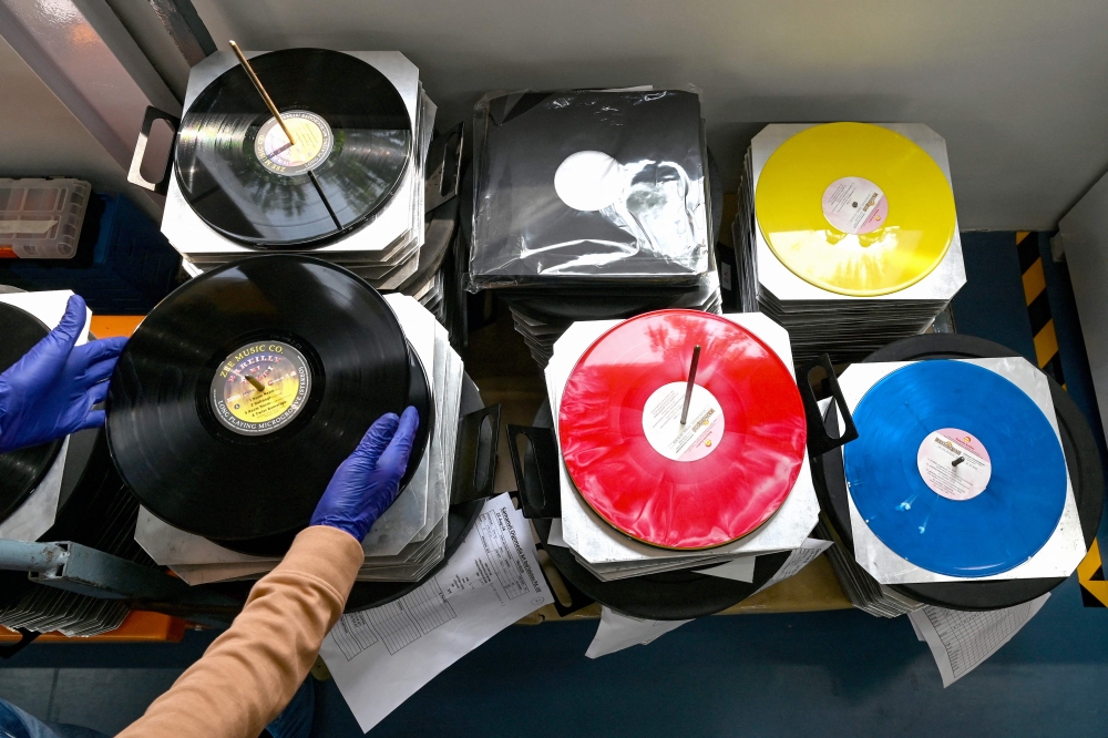 In this photograph taken on September 21, 2024, an employee arranges freshly stamped vinyl records at Samanvii Digimedia Art and Solutions pressing plant in Navi Mumbai. — AFP pic