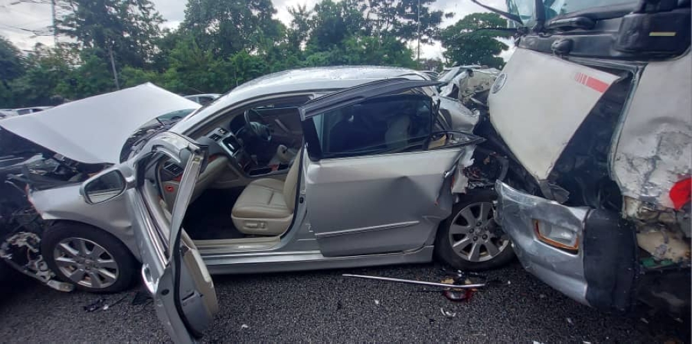 Three individuals, including a woman, suffered minor injuries after a five-tonne lorry rammed 11 cars and a motorcycle along the Middle Ring Road 2 yesterday. — Picture courtesy of the Fire and Rescue Department 