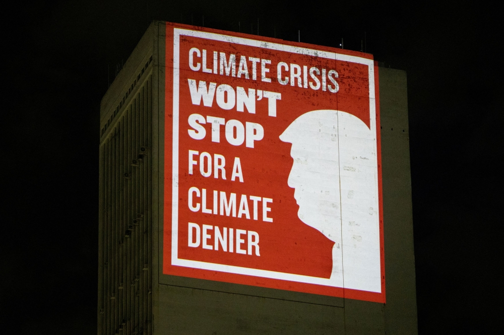 Climate activists from the Glasgow Actions team project a message depicting US President-elected Donald Trump on a building during the G20 Summit in Rio de Janeiro, Brazil November 18, 2024. — Reuters pic  