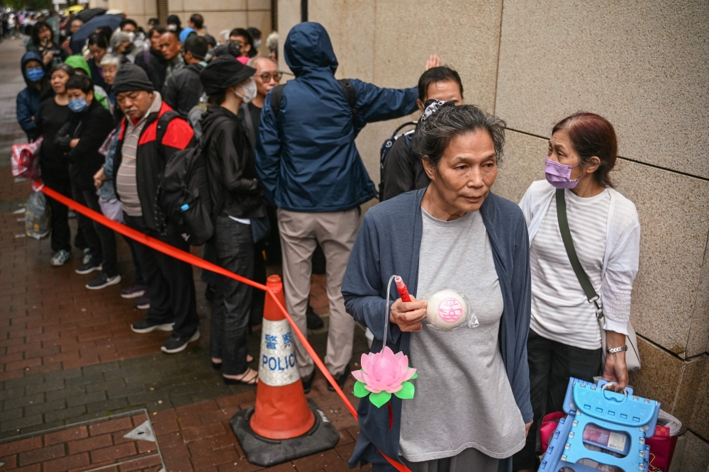 People queue to enter the West Kowloon Magistrates' Court in Hong Kong on November 19, 2024. — AFP pic