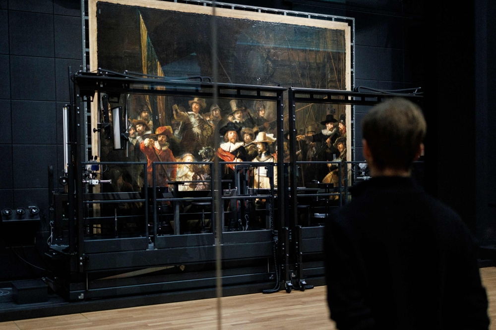 Shielded from the public by glass panels and staring intently through microscopes, a team of specialists has started work restoring Rembrandt’s ‘The Night Watch’, one of the most iconic paintings of the Dutch golden age. — AFP pic