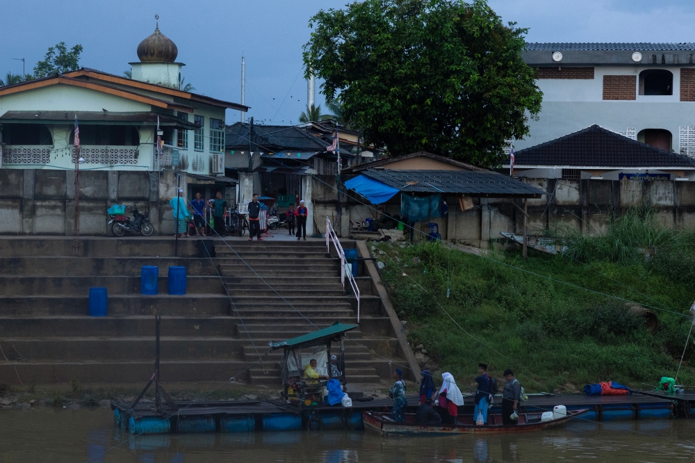 School students use an illegal route on a boat to cross the Malaysia-Thailand border to start the school session November 19, 2024. — Bernama pic