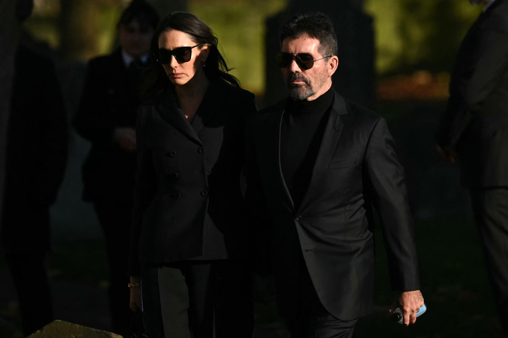 Simon Cowell and Lauren Silverman leave after attending the funeral service. –– AFP pic