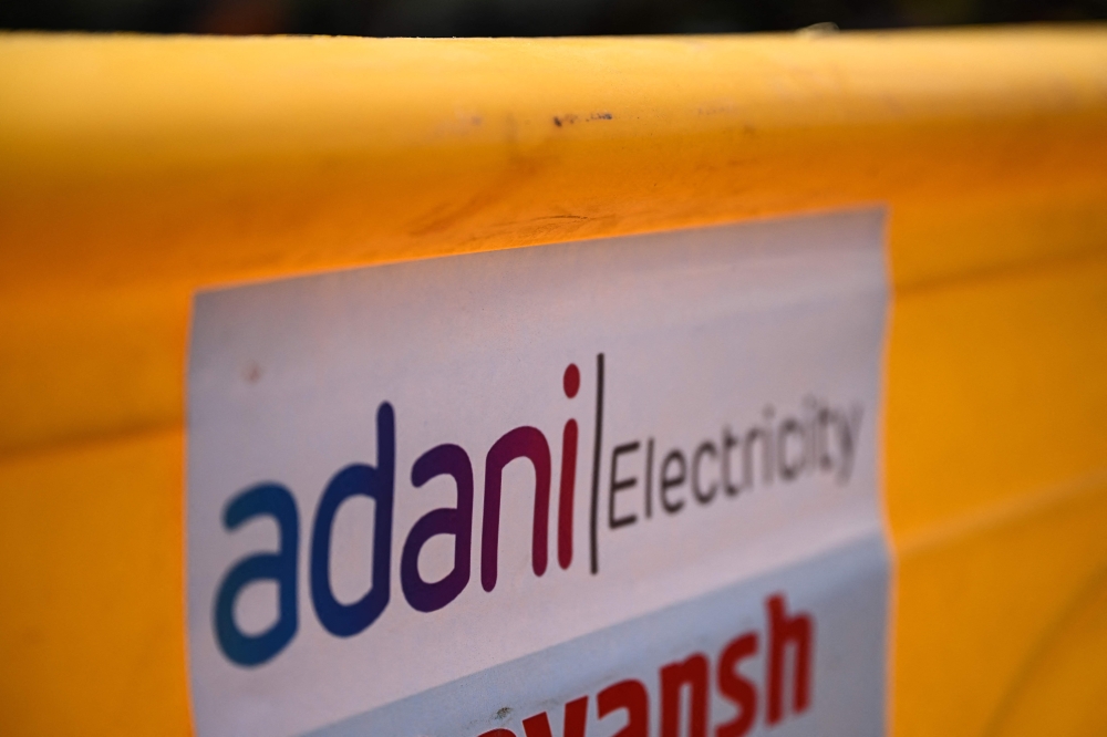 A logo of Adani Electricity Mumbai Limited (AEML) is pictured at a site along the street in Mumbai on November 21, 2024. — AFP pic