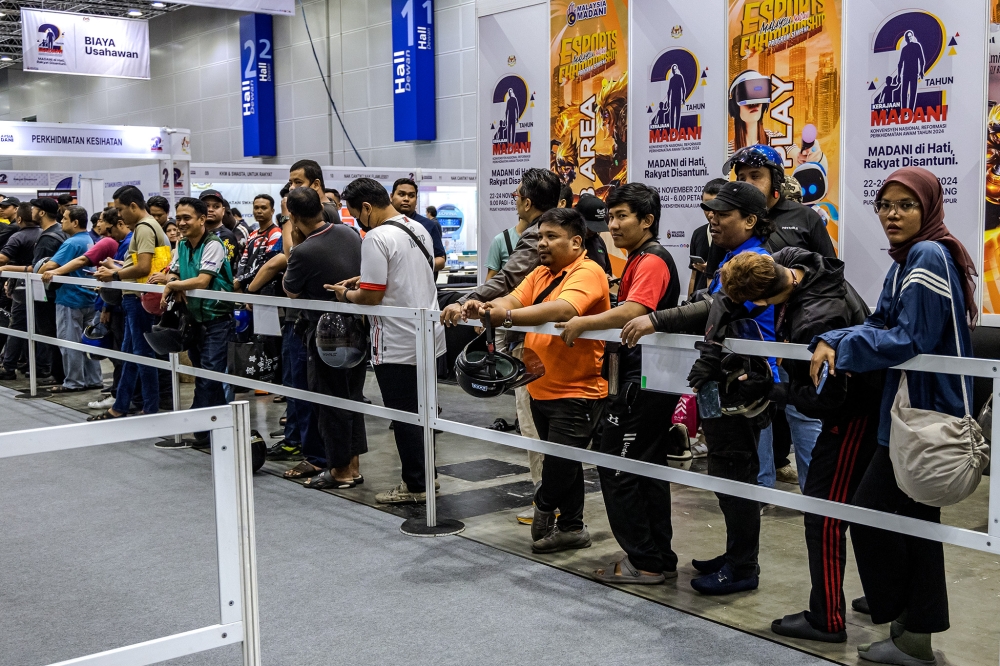 Attendees queue for the Helmet Exchange Program during the Madani Government's two-year anniversary event at the Kuala Lumpur Convention Centre on November 22. 2024. — Picture by Firdaus Latif