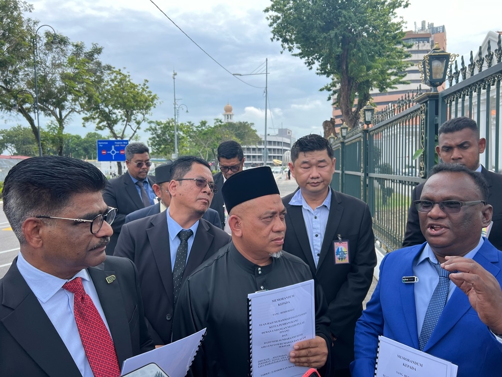 Permatang Damar Laut resident representative M. Annathurai, 55, (right) hands over a memorandum to state exco Datuk Seri S. Sundarajoo (left) and state opposition leader Muhammad Fauzi Yusoff (centre) outside the state legislative assembly November 22, 2024. — Picture by Opalyn Mok