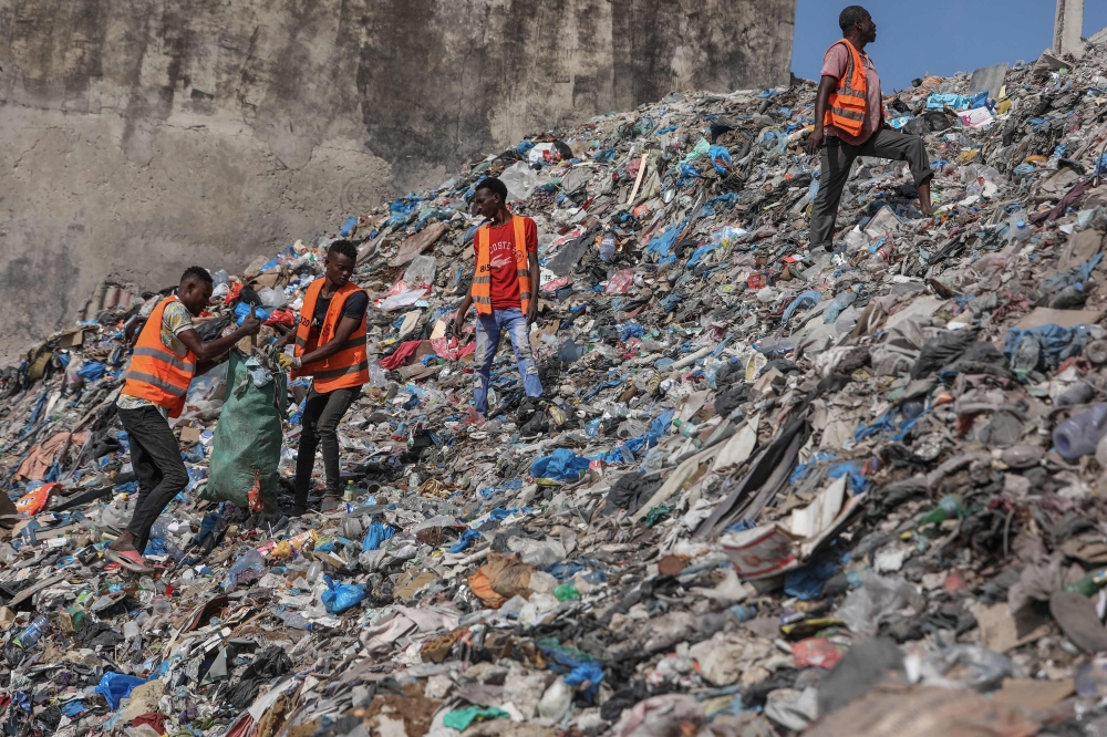 A group of cleaners rummages through piles of trash along side of Hamarweyne beach in Mogadishu on November 9, 2024. Plastic pollution litters our seas, our air and even our bodies, but negotiators face an uphill battle next week to agree the world's first treaty aimed at ending the problem. Countries will have a week in South Korea's Busan from November 25, to round off two years of negotiations. — AFP pic