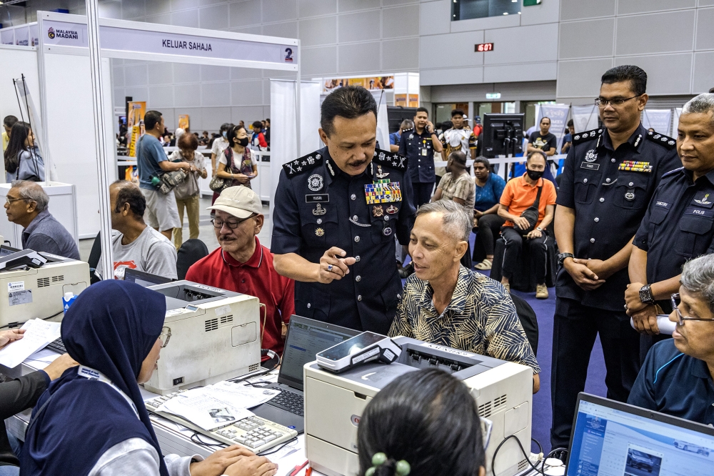 Bukit Aman Traffic Investigation and Enforcement Department director Datuk Seri Mohd Yusri Hassan Basri speaks to visitors at the PDRM booth during the Madani Government's two-year anniversary event at the Kuala Lumpur Convention Centre November 22, 2024. — Picture by Firdaus Latif