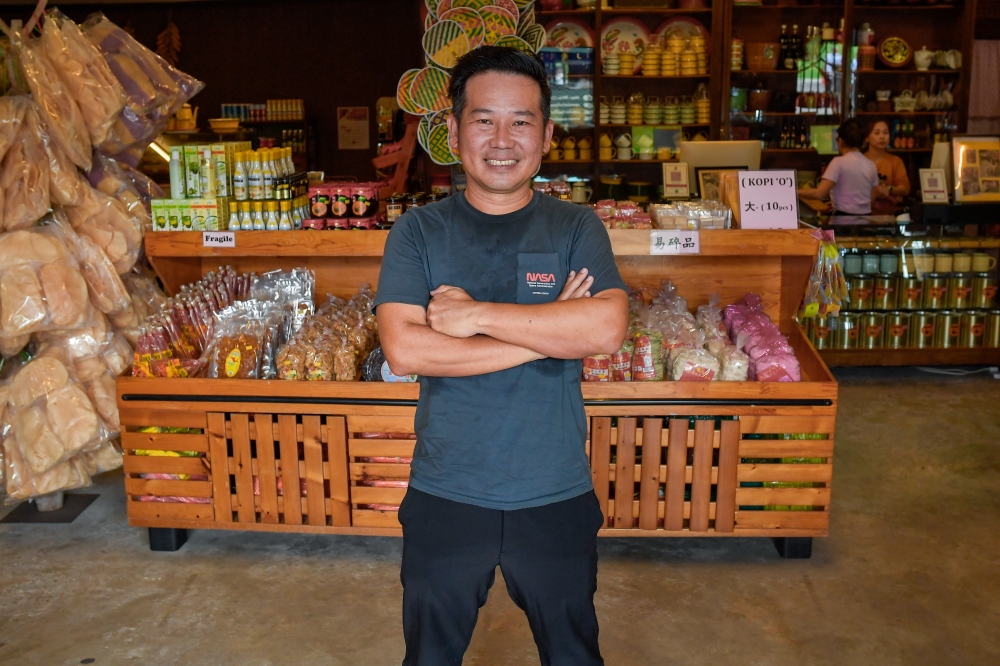 Ng Joo Leong, who manages Ah Ma House with his wife Kwi Ai Fang, poses for a picture in front of a display of nostalgic treats. — Bernama pic