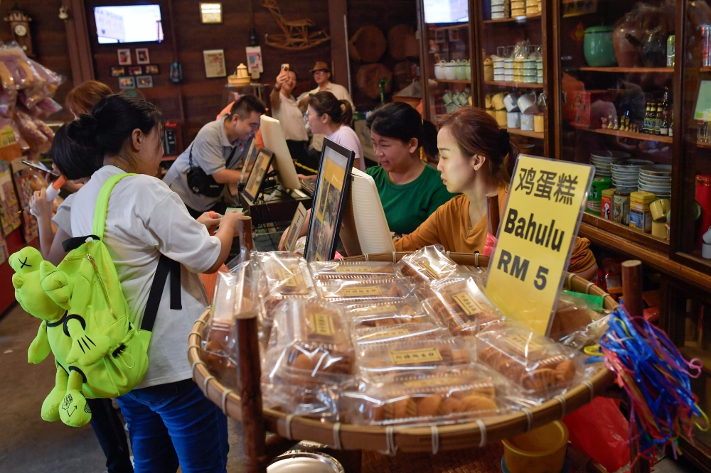 Visitors buy nostalgic snacks at Ah Ma House in Sekinchan. — Bernama pic