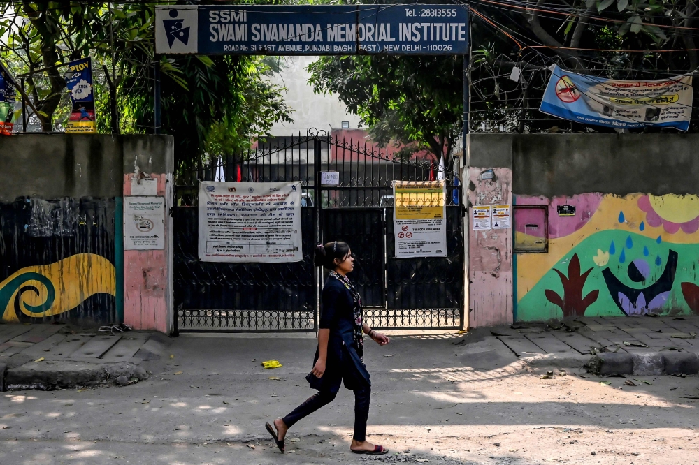 A girl walks past Swami Sivananda Memorial Institute whilst school is closed due to dense smog in New Delhi on November 22, 2024. — AFP pic