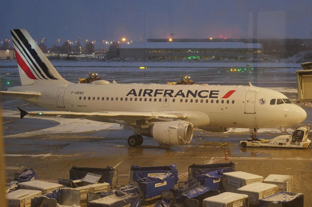 An Air France plane with snow on the tarmac at the Roissy-Charles de Gaulle airport north of Paris, France as Storm Caetano hit on November 21, 2024, causing flight delays after  authorities asked airlines to abandon 10 per cent of their flights. — AFP pic