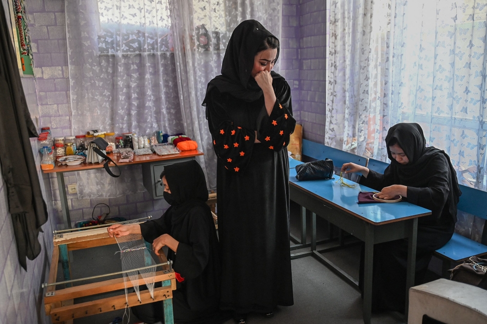 Khadija Mohammadi, a businesswoman, watches her employees working at a handicraft workshop centre in Kabul November 10, 2024. — AFP pic