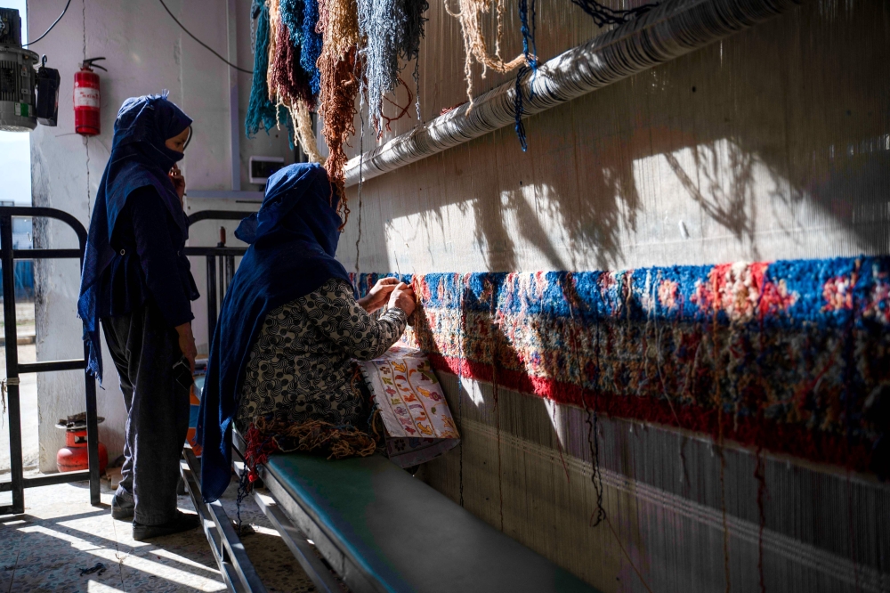 Afghan women weave carpets at a factory on the outskirts of Kabul. Many women have launched small businesses in the past three years to meet their own needs and support other Afghan women, whose employment sharply declined after the Taliban authorities took power in 2021, imposing rules that squeezed women from many areas of work and public life. — AFP pic