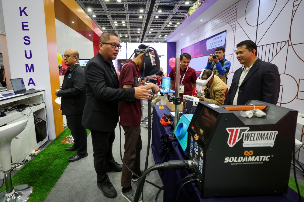 Staff from the Ministry of Human Resources assisting visitors in using a welding simulator at the Ministry’s booth (KESUMA) during the MADANI Government’s Two-Year Programme at the Kuala Lumpur Convention Centre (KLCC) today. — Bernama pic