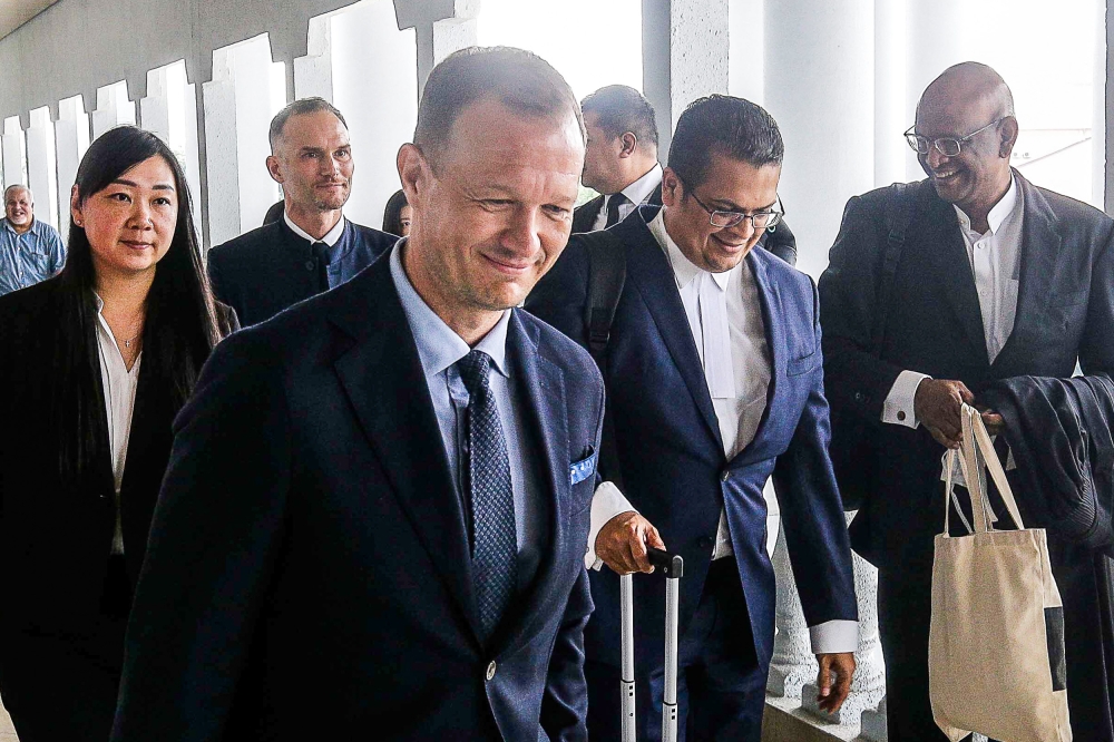 Lawyer Nizam Bashir (right) along with 2 foreigner who believed to be representative from Swatch were seen exiting the court room after the Swatch Malaysia Pride Watch case at Kuala Lumpur Court Complex April 23, 2024. — Picture by Sayuti Zainudin