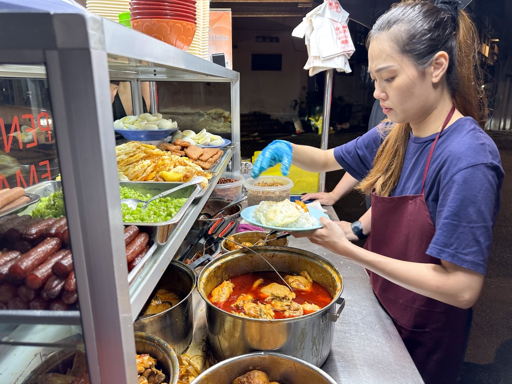 Order your ‘nasi lemak’ and they will ladle on the items for you. — Picture by Lee Khang Yi