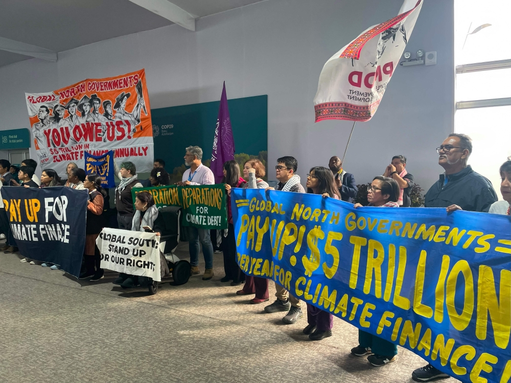 Activists with banners and flags hold a gathering to demand that rich countries help developing nations tackle global warming, during the UN Climate Change Conference (COP29) in Baku, Azerbaijan, on November 21, 2024. — AFP pic