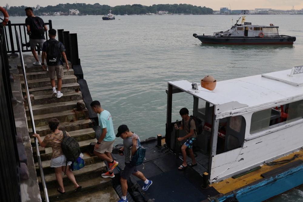 Visitors disembark a bumboat at the jetty on Singapore’s Pulau Ubin island November 1, 2024. — Reuters pic