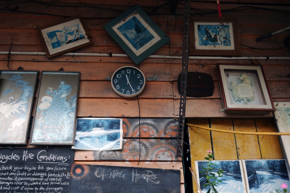 A clock hangs amongst other decorations on the wall of Lim Cyse See’s bicycle repair shop on Singapore’s Pulau Ubin island November 1, 2024. — Reuters pic