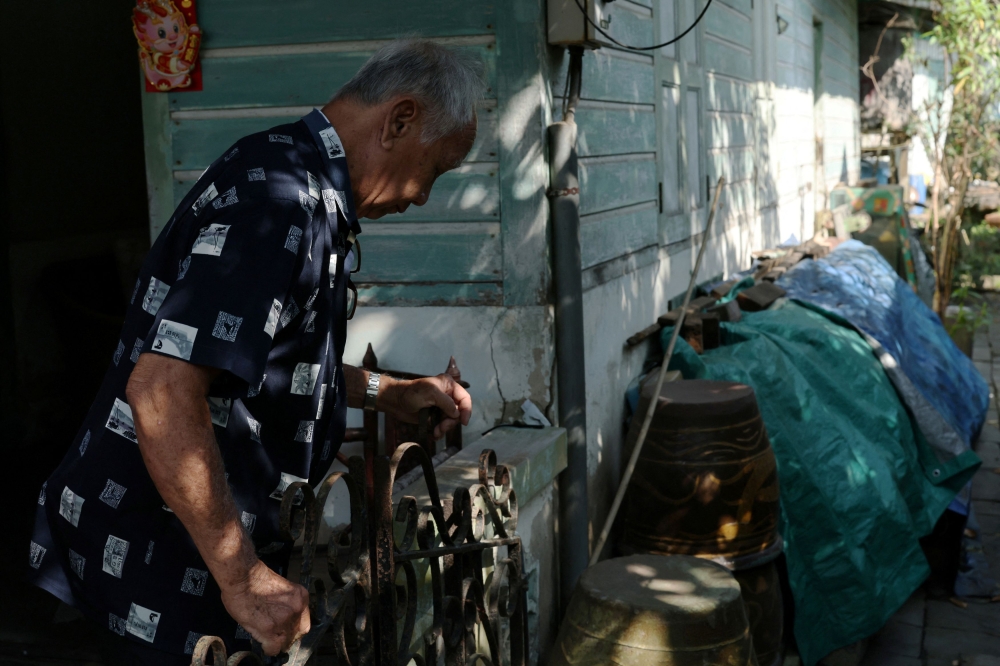 Resident Chu Yok Choon, 79, closes a gate on his front porch on Singapore’s Pulau Ubin island November 1, 2024. — Reuters pic