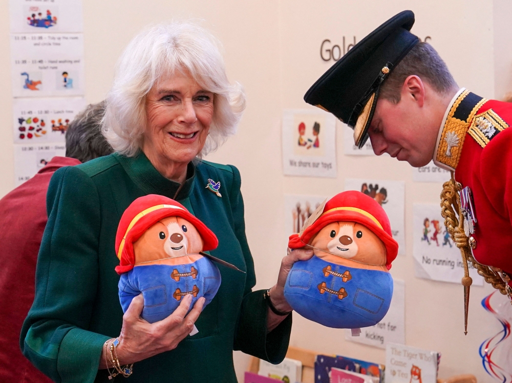 Britain's Camilla, Queen Consort holds Paddington bear teddies before distributing them to children during a visit to Barnardo's Nursery in Bow, east London November 24, 2022. — Arthur Edwards/Pool/AFP pic 