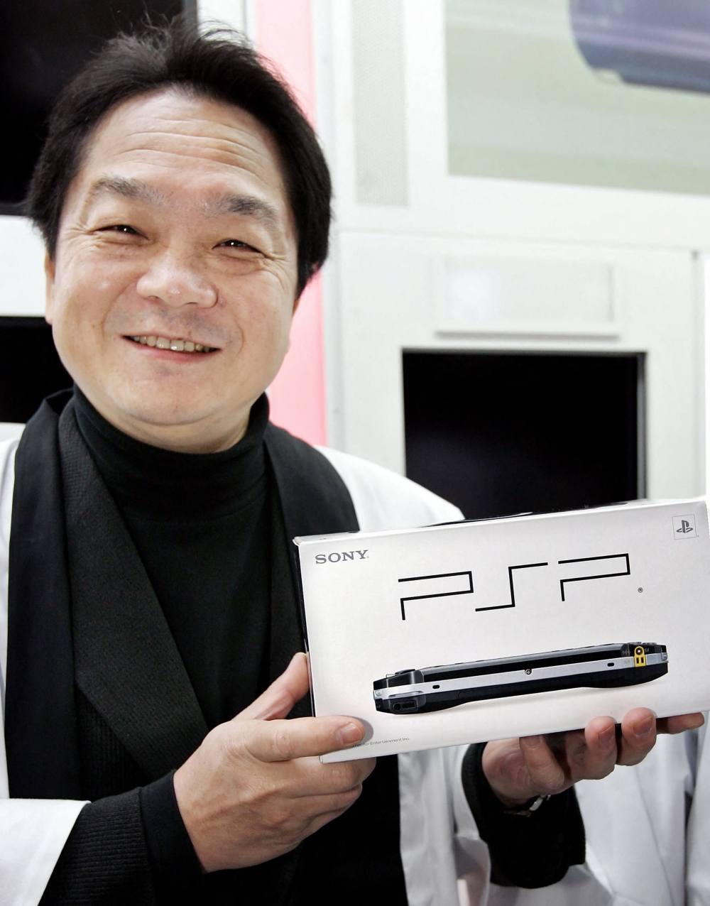 Sony Computer Entertainment president Ken Kutaragi poses with the new handheld video game console PlayStation Portable (PSP) at a Tokyo electrics shop on December 12, 2004. — AFP file pic