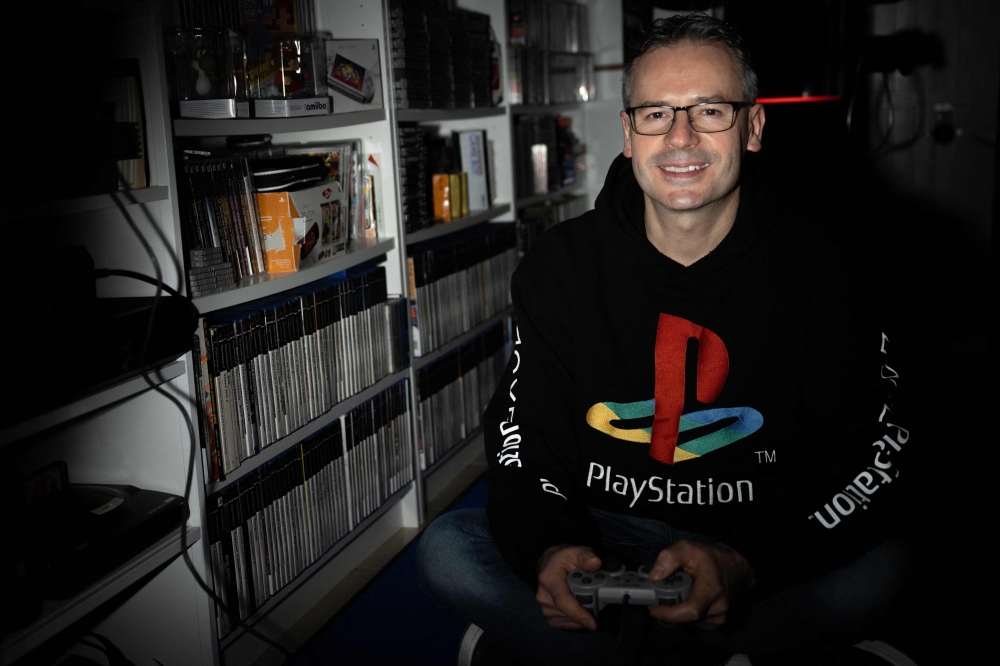 French PlayStation' collector Cyril, poses with a PlayStation 1 controller and hoodie, at his home in Vraiville, on November 20, 2024. — AFP pic