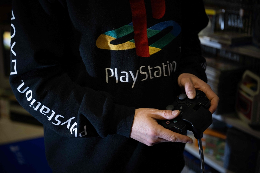 This photograph taken on November 20, 2024 shows a a PlayStation console controller, in Vraiville. — AFP pic