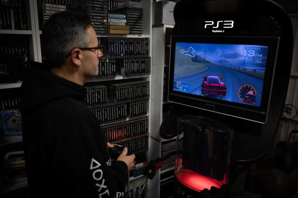 French PlayStation' collector Cyril, plays to PlayStaion 3, at his home in Vraiville, on November 20, 2024. — AFP pic