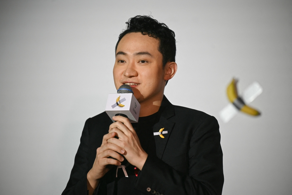 Chinese-born crypto founder Justin Sun speaks before eating a banana artwork composed of a fresh banana stuck to a wall with duct tape, in Hong Kong on November 29, 2024, after buying the provocative work of conceptual art by Italian artist Maurizio Cattelan at a New York auction for US$6.2 million. — AFP pic