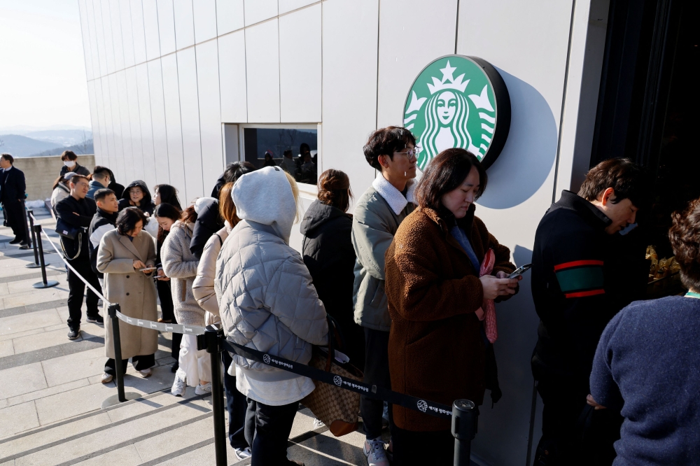 Customers queue up in front of the new store of Starbucks at the top of the Aegibong Peak Observatory, south of the demilitarized zone (DMZ), separating the two Koreas, in Gimpo, South Korea November 29, 2024. Visitors must pass through a military checkpoint on the way to the Starbucks outlet. — Reuters pic  