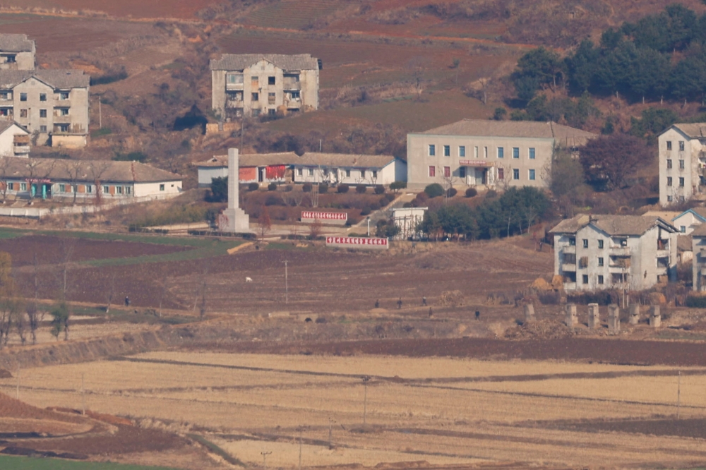 North Korean citizens walk in North Korea's propaganda village Kaepoong, in the picture taken from the top of the Aegibong Peak Observatory, south of the demilitarised zone (DMZ), separating the two Koreas in Gimpo, South Korea November 29, 2024. — Reuters pic  