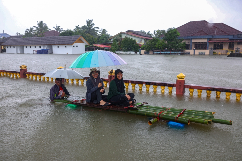 Residents are cheerful despite the high flood water level around their residence following continuous rain for the past few days in Kampung Lati in Pasir Mas November 29, 2024. — Bernama pic