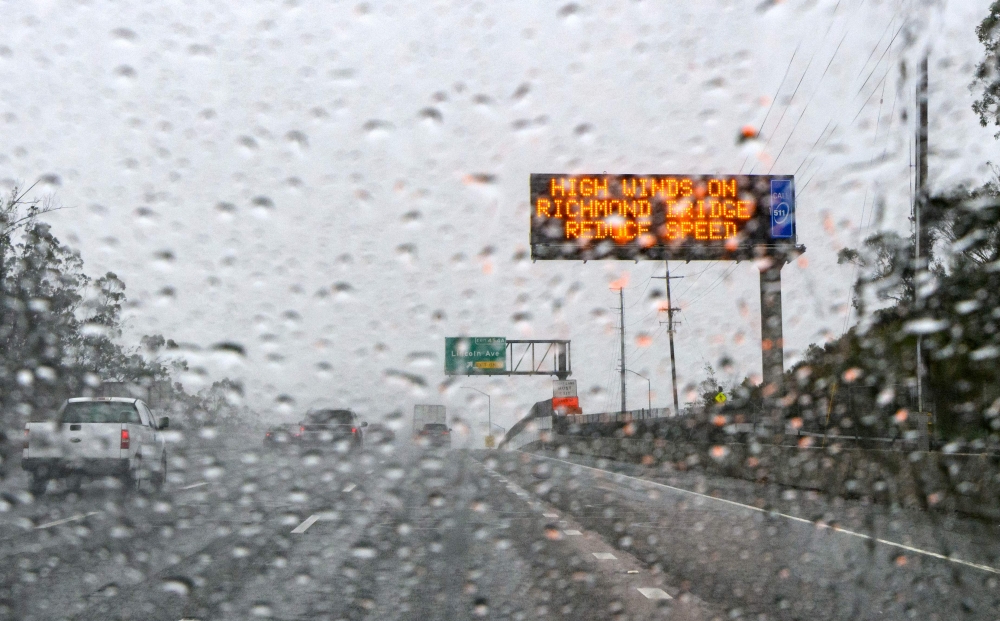 A traffic sign warns of inclement weather in San Rafael, California January 4, 2023. A bomb cyclone smashed into California on January 4, 2023, bringing powerful winds and torrential rain. — AFP pic