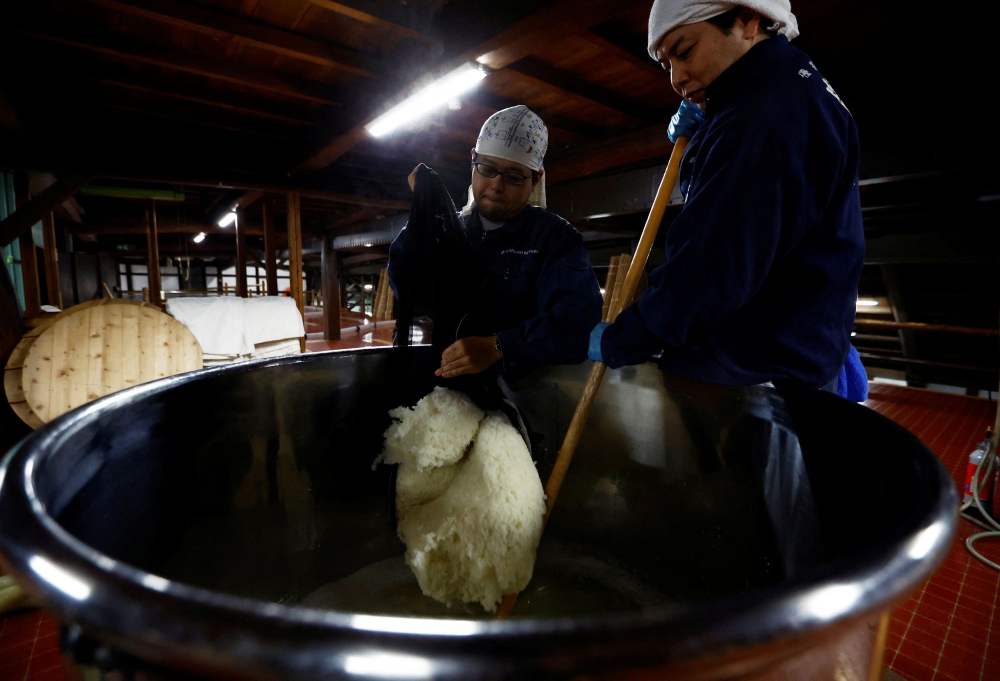 Brewers stir the mixture in a container to make a yeast starter, an important ingredient used in brewing sake, a traditional Japanese rice wine, at Ishikawa Shuzou, or Ishikawa Brewery, in Fussa, western portion of Tokyo, November 25, 2024. — Reuters pic 