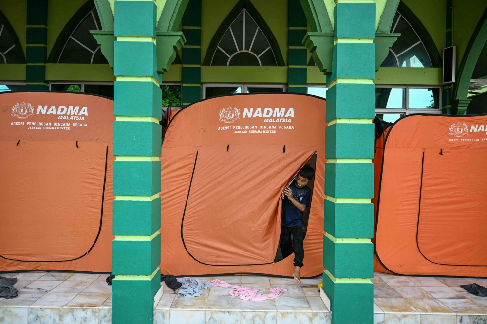 A young evacuee at a shelter in Pasir Mas. — AFP pic