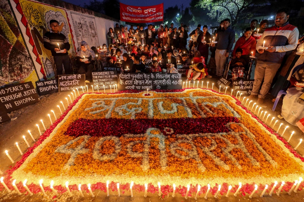 Second and third generation children of the 1984 Bhopal Gas Leak Disaster victims and members of the Chingari Rehabilitation Centre hold candles as they pay tribute to the victims on the eve of its 40th anniversary near the defunct Union Carbide pesticide plant in Bhopal on December 1, 2024. — AFP pic