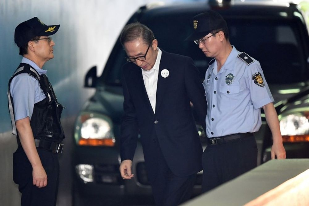 Former South Korean president Lee Myung-bak (centre) arrives at a court to attend his trial in Seoul on September 6, 2018. — AFP pic