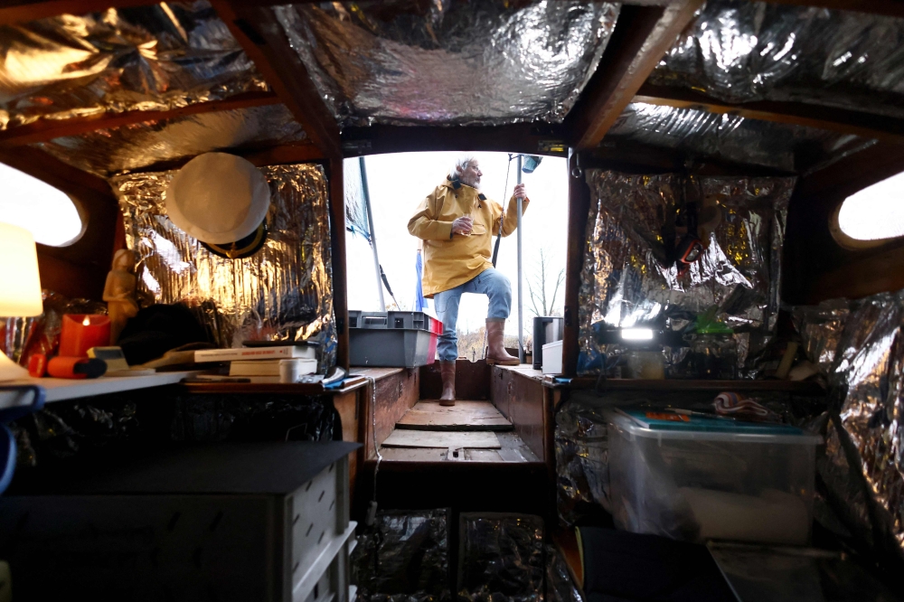 Frenchman Bernard Poitau poses on his boat ‘Anticylone’ as he takes part in the Vendee Globe, the solo non-stop round the world yacht race, on the Virtual Regatta sailing race simulator, spending 22 hours a day on a boat on slipways in his garden to raise charity funds in Saint-Julien-Molin-Molette, central-eastern France December 3, 2024. — AFP pic