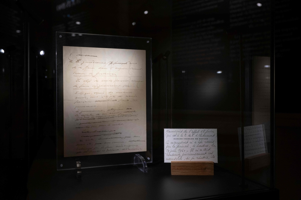 This photograph taken on December 6, 2024, shows a pages from original manuscript of General de Gaulle’s 1940 ‘Appeal of June 18’ along with a card from General de Gaulle’s wife Yvonne, displayed ahead of an auction of General de Gaulle’s personal memorabilia and writings (the manuscript displayed in the photograph is not up for sale, however), at Artcurial auction house in Paris. — AFP pic