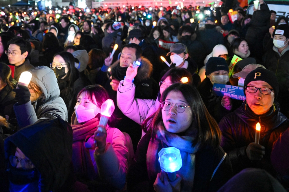 People take part in a protest calling for the ouster of South Korea President Yoon Suk Yeol outside the National Assembly in Seoul on December 7, 2024. Nearly 150,000 people attended a rally outside South Korea's parliament on December 7, Yonhap reported, demanding Yoon step down as lawmakers inside struggled to muster the votes to impeach him. — AFP pic